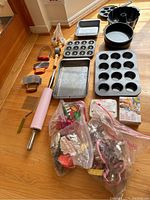Full lot on floor showing baking pans, cookie cutters, rolling pin, and decorating tools.