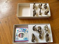 Two white boxes with silver birthday candle holders and a box of striped candles inside one box.