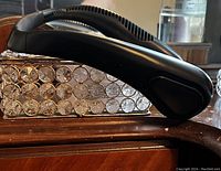 Side view of the black flexible neck fan resting on a wooden surface.