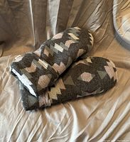 Photo of the mittens lying side by side showing pattern and sherpa lining.