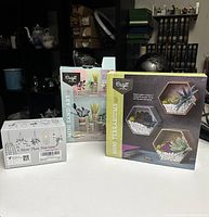 Three new craft kits: Mini Sand Art, Mini Terrariums, and More Than Macrame, displayed on a white surface.