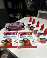 Craft supplies arranged on a white surface showing air dry clay packs, Crayola marker sets, and Calvin glue bottles.