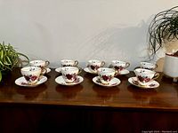 Set of 8 Royal Imperial teacups and saucers arranged on a wooden surface.