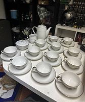Full set of vintage Mikasa coffee/tea set on tabletop including cups, saucers, cream dish, sugar bowl, and tea pot.