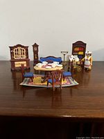 Full set arrangement shown on wooden table highlighting all included furniture pieces and figure.