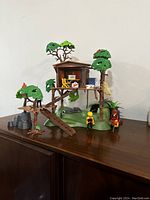 Front view of the Playmobil Adventure Treehouse with figures and accessories placed on a wooden surface.