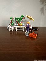 Photo showcasing the complete vintage Playmobil Victorian Garden Terrace set with figures and garden accessories arranged on table surface.