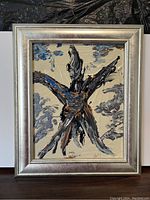 Framed painting showing abstract figure with bold brushstrokes in black, blue, white and brown hues, set in silver custom frame.