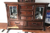 Front view of the Liberty Furniture five drawer server with beveled glass doors and decorative molding, showing drawer and door pulls.