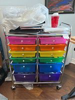Front view of metal storage cart with colorful plastic drawers and items on top