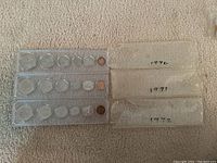 Three plastic holders each containing six Canadian coins for years 1970, 1971, and 1972 arranged on carpet, showing front view of sets.