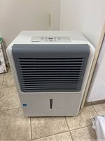 Full view of the white Danby dehumidifier showing the gray front air vent and general condition.