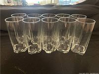 Front view of 10 clear tall glasses arranged in a row showing 6 tall and 4 shorter glasses.