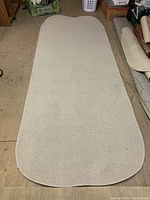 Full view of the light-colored area rug showing rounded edges and overall shape.