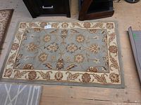 Top view of the wool area rug showing the floral pattern and surrounding furniture.
