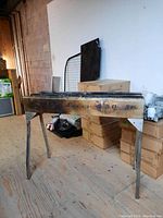 Front angled view of the rectangular metal charcoal barbecue showing the foldout legs and embossed text on the side.