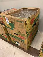 Three cardboard boxes filled with clear glass mason jars, no lids included, stacked and visible from top and side.