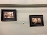 Two sepia toned landscape prints shown side by side on wall, framed in dark wood float frames.