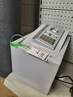 White electronic safe model SE120148 with keypad and key lock shown from front-left angle on a display shelf in a storage environment.