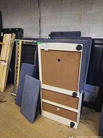 Photo of sectional couch parts showing backing and side panels with storage seats and fabric upholstery.