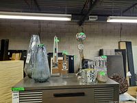 Photo showing various glass vases, candle holders, and decor pieces on display.