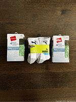 Front view of two Hanes briefs packages and one Puma socks package with size medium labels visible.