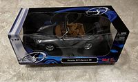 Side view of boxed gray Maisto Porsche 911 Carrera 4S model car showing packaging and car details.