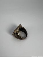 Side view of owl ring showing detailed feather texture and band shape.