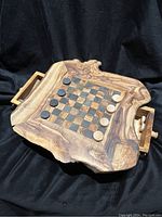 Front view of the wooden checkers set showing the playing board with natural edges, checkers pieces arranged on the board, and one storage door opened with handle visible.