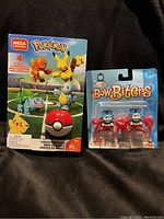 Front view of Pokémon Mega Construx building set and Thomas the Tank Engine Bow Biters shoelace toppers in packaging