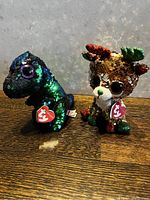 Front view of dinosaur and reindeer Beanie Babies with Ty tags.