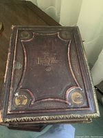 Front cover close-up of large antique family Bible with embossed leather cover and gold gilt lettering and design