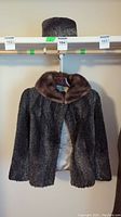 Full view of the Persian wool jacket with attached brown mink collar and matching pillbox hat above.