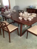 Several mahogany chairs around dining table showing frames and upholstery