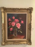 Full view of acrylic painting in ornate gold frame hanging on wall, showing the pink roses in vase still life scene.