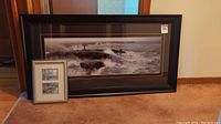 Overview of three framed prints: one large panoramic coastal lighthouse photo print and two smaller Keirstead prints framed together.