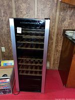 Front view of Sanyo SR-W4500 wine cooler showing black glass door with silver framing and wooden shelves inside.