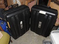 Front view of both black rolling hard cases showing ribbed design and labels