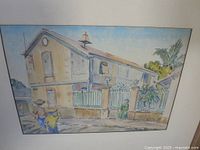 Framed watercolor showing stucco house, figures and fence