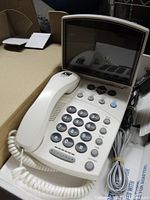 Open box showing CapTel 840 telephone with handset, cords, display