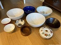 Photo showing ten assorted wood and ceramic bowls grouped on floor including Royal Worcester bowl with lid