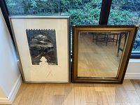 Photo showing both the framed James Joyce quote artwork and the large ornate framed mirror side by side on a wooden floor near a glass window.