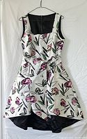 Black and white reversible Forest Lily dress with stylized floral print, showing front and sash detail.