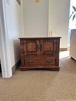 Front view of the square end table showing double cabinet doors and bottom drawer with hardware.