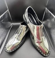 Pair of Design Lab silver metallic zip-front slip-on shoes with stud detail on sole, size 9.5.