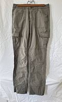 Front view of casual cargo pants in neutral color with multiple pockets