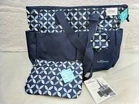 Front view of BabyBoom Ivy tote diaper bag with geometric pattern and multiple exterior pockets, showing attached tags and price sticker.