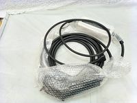 Coiled black EV charging cable with bubble wrap protection on connectors