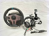 Gaming racing set items displayed on white background: steering wheel, joystick, headset