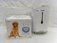 Photo showing the boxed automatic ball launcher with dog image and branding visible